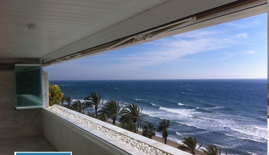 Terraza frente al mar cerrada con cortina de cristal